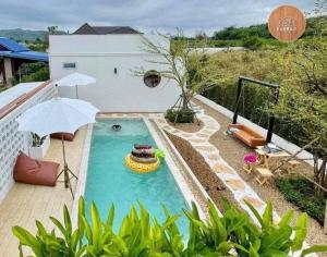 a swimming pool with a raft in the middle of a house at Banrao Pool Villa Khaoyai บ้านเราพูลวิลล่าเขาใหญ่ in Ban Tha Maprang