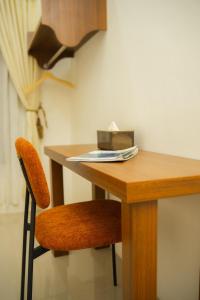 a wooden desk with a chair and a box of tissues at Bylina House in Batu