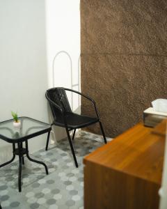 a black chair and a table in a room at Bylina House in Batu