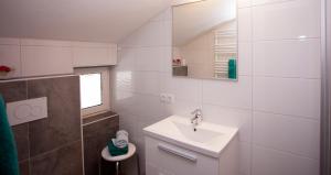 a white bathroom with a sink and a mirror at Haus Tyrol in See +41 photos