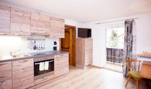 a kitchen with wooden cabinets and a sink and a window at Haus Tyrol in See
