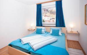 a bedroom with a blue bed with blue curtains and a window at Haus Tyrol in See