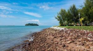 a rocky shore with trees and the ocean at Sea Front Hotel Port Dickson in Kampong Arab