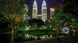 a view of a park at night with tall buildings at Grand Barakah Hotel in Kuala Lumpur