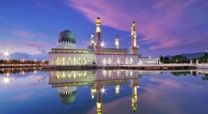 a mosque with its reflection in the water at night at ATAP Hotel in Kota Kinabalu