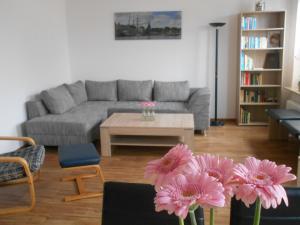 ein Wohnzimmer mit einem Sofa und rosa Blumen in der Unterkunft Ferienwohnung Parkgarten in Flensburg