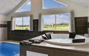 a large bathroom with a tub and a swimming pool at Holiday Home Vejby With Fireplace 05 in Vejby +17 photos