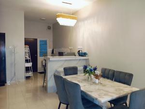 a dining room with a table and blue chairs at Santai Homestay PD in Port Dickson