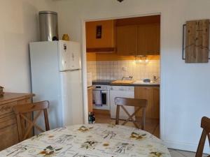 une cuisine avec une table et un réfrigérateur blanc dans l'établissement Appartement 3 pièces pour 6 pers, animaux admis, proche pistes - FR-1-636-234, à Orcières 6 autres photos