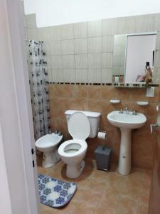 a bathroom with a toilet and a sink at Departamentos Mariano in Cosquín
