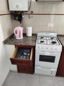 a kitchen with a stove and a counter top at Departamentos Mariano in Cosquín +32 photos
