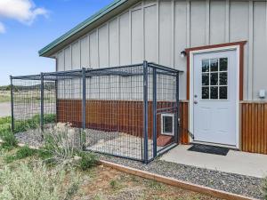 a large dog cage in front of a house at Cedar Mountain Bunkhouse cabin in Montrose