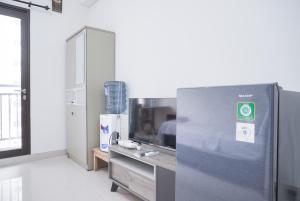 une cuisine avec un réfrigérateur en acier inoxydable dans une pièce dans l'établissement Cozy Living Studio Transpark Cibubur near Shopping Center Apartment By Travelio, à Depok