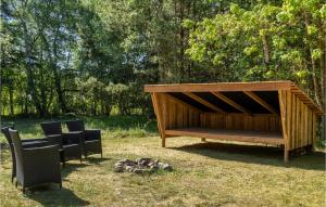 a wooden bench sitting in the grass with chairs at Gorgeous Home In Højby With Wifi in Højby +20 photos