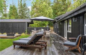 a deck with chairs and a table and an umbrella at 3 Bedroom Pet Friendly Home In Græsted in Græsted +10 photos
