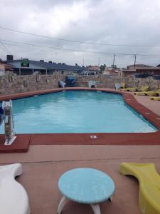 una gran piscina con una mesa y una silla en White Sands Inn, Marina, Bar & Grill, en Port Isabel