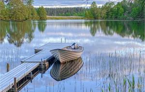 a boat sitting at a dock on a lake at 2 Bedroom Amazing Home In Tranås in Tranås +10 photos