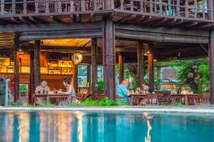 a group of people sitting at tables outside a restaurant at The Central Lovina Hotel & Restaurant in Lovina