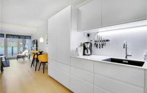 赫尔辛格Lovely Apartment In Helsingør With Wifi的一间厨房,配有白色橱柜和一间餐厅