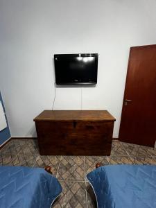a tv on a wall with a dresser and a bed at Acogedora casa Vacacional en Valle Hermoso Cordoba in Valle Hermoso