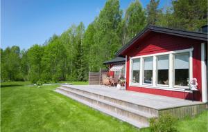 une cabane rouge avec deux chiens assis sur une terrasse dans l'établissement 2 Bedroom Amazing Home In Vindeln, à Vindeln 8 autres photos