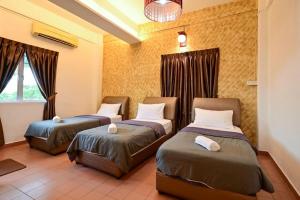 a room with two beds and a window at First Star Homestay - Self Check In in Kluang +11 photos
