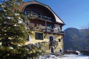 un grande edificio con balcone e albero di Belvedere a Semmering