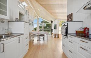 a kitchen with white cabinets and a dining room at Stunning Home In Børkop in Børkop
