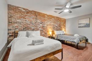Ideal Spot Near 4th Street Live & Local Dining في لويزفيل: غرفة نوم بها سريرين وجدار من الطوب