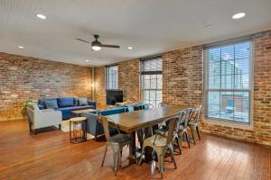 Ideal Spot Near 4th Street Live & Local Dining في لويزفيل: غرفة معيشة بجدار من الطوب وطاولة وكراسي