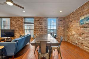 Ideal Spot Near 4th Street Live & Local Dining في لويزفيل: غرفة مع طاولة وكراسي وجدار من الطوب +52 صورة