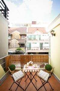 Un patio con una mesa y sillas en un balcón. en Asokes Hidden Gem Cozy Stay Next to the Park, en Bangkok