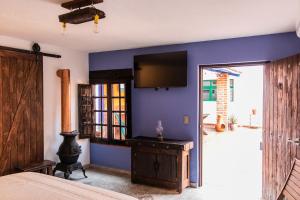 a bedroom with a tv on a blue wall at Casa de hospedaje -La Abadía de San Pedro in Guadalajara