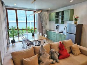 a living room with a couch with two stuffed animals on it at the 50 house hatyai บ้าน50หาดใหญ่ in Ban Kohong +25 photos