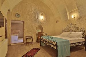 Jacob's Cave Suites - Cappadocia في غوريمِ: غرفة نوم بسرير كبير في غرفة بها قوس