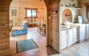 una cucina e una sala da pranzo in una baita di tronchi di Nice Home In Mscice With Kitchen a Mścice