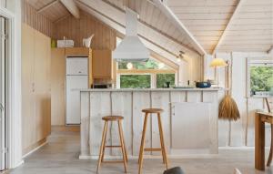 a kitchen with a counter and two stools at Three-Bedroom Holiday Home In Sjallands Odde in Yderby
