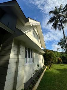 a white house with a palm tree next to it at River Wild holiday home in Athirappilly