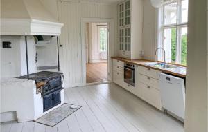 a white kitchen with a stove and a sink at 4 Bedroom Stunning Home In Ödeshög in Ödeshög +23 photos