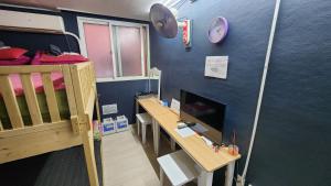 a room with a bunk bed and a desk with a computer at Daejeon Guesthouse Sky Garden in Daejeon