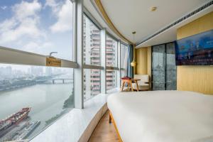 Schlafzimmer mit einem großen Fenster mit Flussblick in der Unterkunft Atour S Hotel Guangzhou Beijing Road Tianzi Wharf-Free Shuttle Bus From Hotel To Pazhou Exhibition Center During Canton Fair in Guangzhou