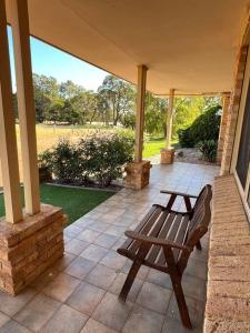 a wooden bench sitting on a porch with a porch at Myra Downs in Harvey
