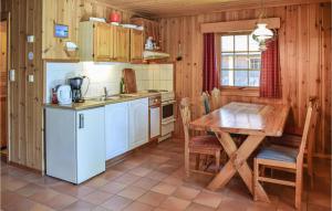 Una cocina con una mesa de madera y una mesa y sillas. en Bjertnes Turistgård, en Noresund