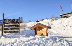 a snow covered building with a sign next to it at 3 Bedroom Cozy Apartment In Ål in Skarsgård