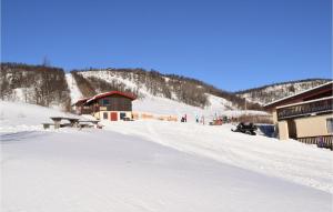 a snow covered mountain with a ski lodge in the background at 3 Bedroom Cozy Apartment In Ål in Skarsgård