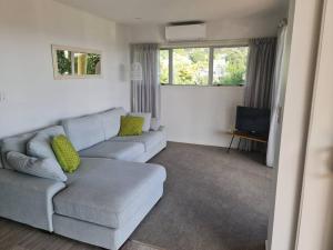 a living room with a couch and a television at By the Sea 3 bedroom Apartment with ocean views in Coopers Beach
