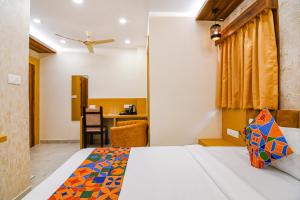 a hotel room with a bed and a desk at FabHotel Sonali Golden Palace - Nr Bhubaneswar Railway Station in Bhubaneshwar +41 photos
