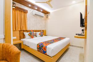 a bedroom with a bed and a television in it at FabHotel Sonali Golden Palace - Nr Bhubaneswar Railway Station in Bhubaneshwar