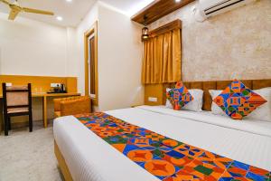a hotel room with a bed and a desk at FabHotel Sonali Golden Palace - Nr Bhubaneswar Railway Station in Bhubaneshwar