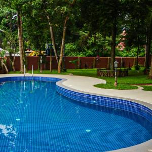 a swimming pool with blue tiles in a park at Puzhayoram holiday home, Aluva in Alwaye